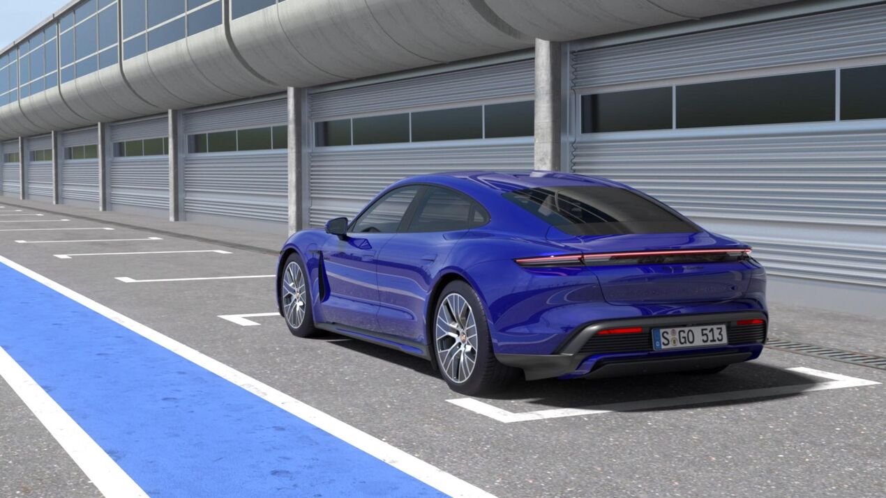 Heckansicht blauer Porsche Taycan vor Garage